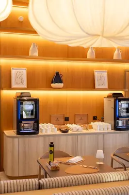 a restaurant with a counter with a tv and tables at Golden Tulip Avignon Le Paradou in Avignon