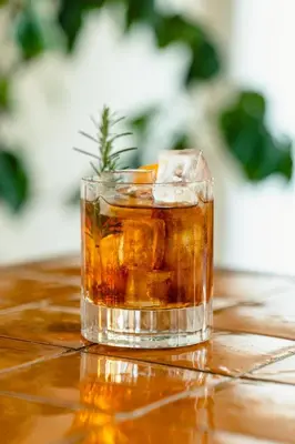 a glass of whiskey on a table at Le Moulin, Lourmarin, a Beaumier Hotel in Lourmarin