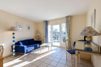 a living room with a blue couch and a table at Residhotel Golf Grand Avignon in Vedène
