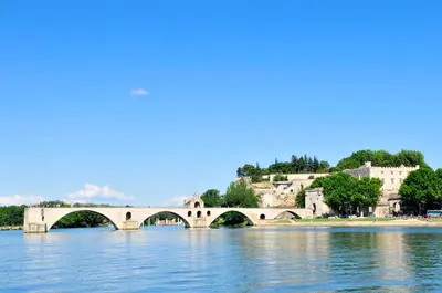 a bridge over the water with buildings in the background at Residhotel Golf Grand Avignon in Vedène