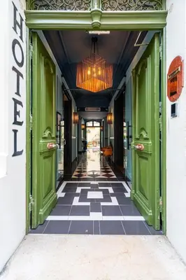 a hallway with green doors and a checkered floor at La Maison d'été in Salon-de-Provence
