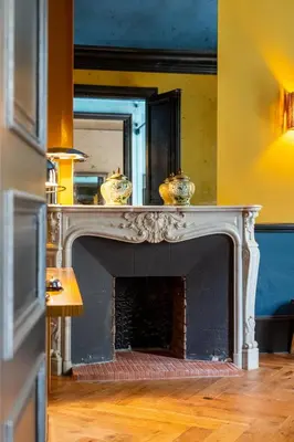 a living room with a fireplace with a mirror at La Maison d'été in Salon-de-Provence