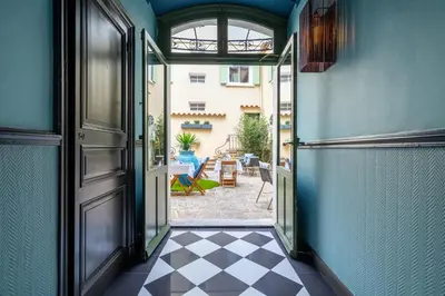 an open door to a courtyard with a patio at La Maison d'été in Salon-de-Provence
