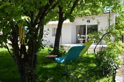 a blue chair in the yard of a house at Charmante maisonnette indépendante avec piscine à Goult in Goult