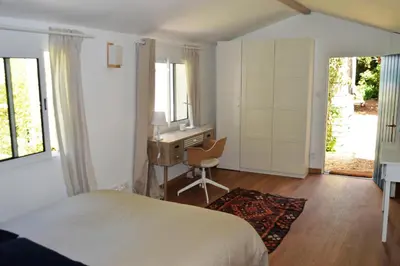 a bedroom with a bed and a desk and a chair at Charmante maisonnette indépendante avec piscine à Goult in Goult