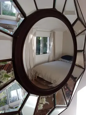 a mirror reflection of a bed in a room at Charmante maisonnette indépendante avec piscine à Goult in Goult