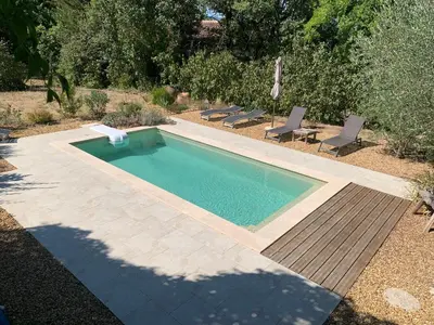 a swimming pool in a yard with chairs around it at Charmante maisonnette indépendante avec piscine à Goult in Goult