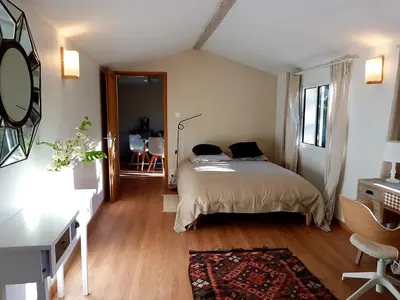 a bedroom with a bed and a desk and a chair at Charmante maisonnette indépendante avec piscine à Goult in Goult