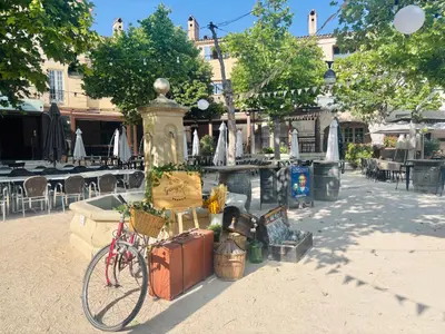 a table with an umbrella in front of a house at Village Pierre & Vacances Pont Royal en Provence in Mallemort