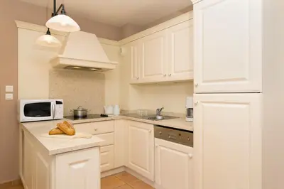 a kitchen with white cabinets and a microwave at Madame Vacances Résidence Provence Country Club in Saumane-de-Vaucluse