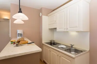 a kitchen with white cabinets and a sink at Madame Vacances Résidence Provence Country Club in Saumane-de-Vaucluse