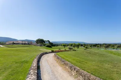a dirt road in a field next to a grass field at Madame Vacances Résidence Provence Country Club in Saumane-de-Vaucluse