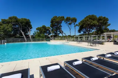 a swimming pool with lounge chairs and trees at Madame Vacances Résidence Provence Country Club in Saumane-de-Vaucluse