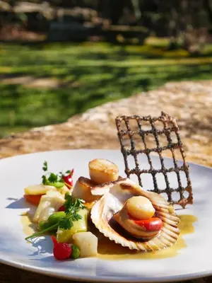 a white plate of food on a table at Mas De La Senancole & Spa in Gordes