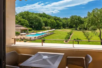 a view from the balcony of a resort with a pool at Mas De La Senancole & Spa in Gordes