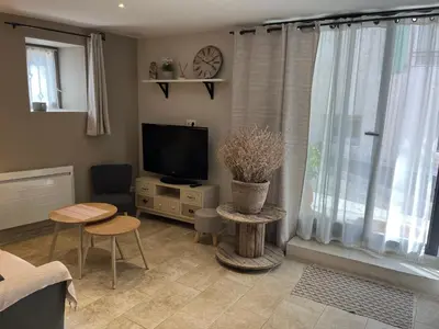 a living room with a flat screen tv and a table at Chez Adeline in Céreste