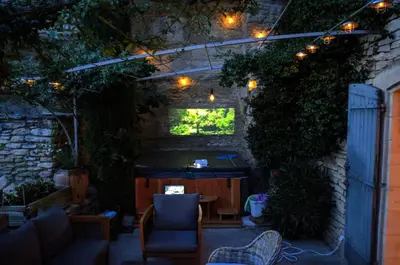 an outdoor patio with a table and chairs and lights at Le Bonheur in Gordes
