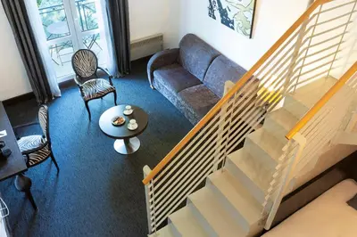 a living room with a couch and a table at SOWELL HOTELS Domaine de la Petite Isle in LʼIsle-sur-la-Sorgue