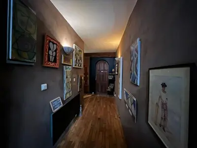 a hallway with paintings on the walls of a house at Fenêtre sur vue in Saignon