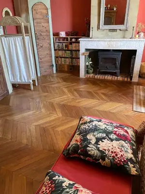 a living room with a fireplace and wooden floors at Fenêtre sur vue in Saignon