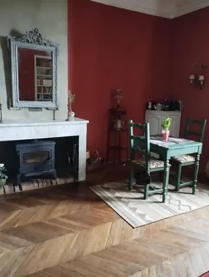 a living room with a table and a fireplace at Fenêtre sur vue in Saignon