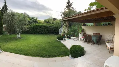 a backyard with a patio and a lawn with chairs at Domaine du Castel in Aix-en-Provence