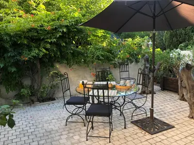 a table and chairs with an umbrella on a patio at Domaine du Castel in Aix-en-Provence
