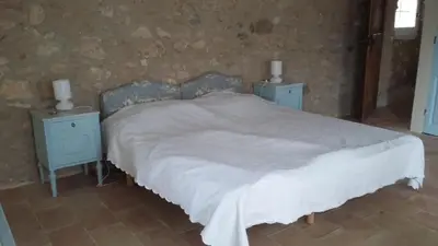 a bedroom with a white bed with two night stands at Villa spacieuse avec jardin à Saignon in Saignon