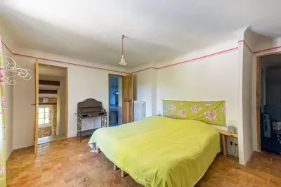 a bedroom with a bed with a green bedspread at Villa spacieuse avec jardin à Saignon in Saignon