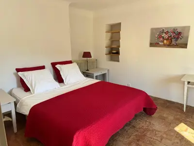 a bedroom with a red blanket on a bed at Villa spacieuse avec jardin à Saignon in Saignon