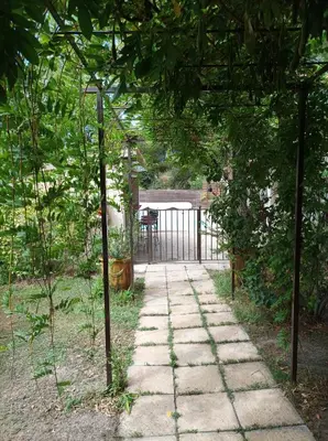 a stone pathway in a garden with a gate at La Campanette en Luberon -Piscine privée in Cheval-Blanc