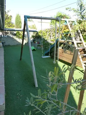 a playground with a swing in a yard at Villa - La quiétude de St Antoine - piscine privée in LʼIsle-sur-la-Sorgue