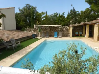 a large swimming pool in a yard with a house at Villa - La quiétude de St Antoine - piscine privée in LʼIsle-sur-la-Sorgue