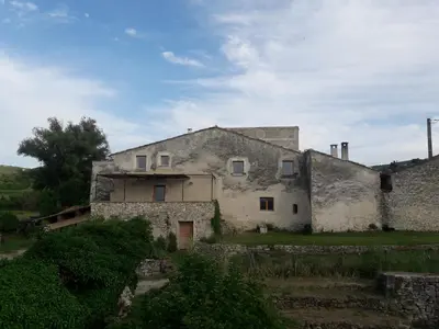 an old stone house sitting on top of a field at Gîte du Mas Saint-Victor in Bonnieux