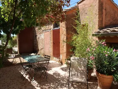 a patio with a table and chairs in front of a building at Holiday Home Les Huppes by Interhome in Saint-Saturnin-les-Apt