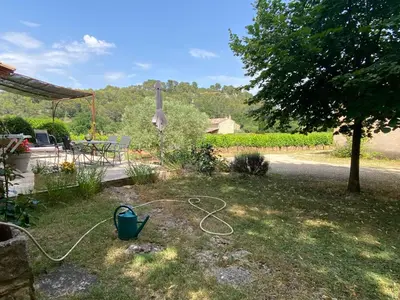 a garden with a garden hose in the grass at La Manaude in Ménerbes