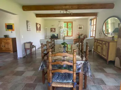 a dining room with a table and a couch at La Manaude in Ménerbes