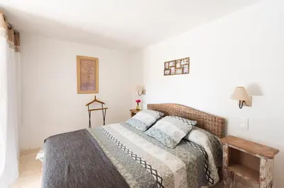 a bedroom with a bed in a room with white walls at Le Mas Silvestre in Saint-Saturnin-les-Apt