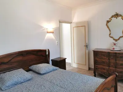a bedroom with a bed and a dresser and a lamp at Aux portes du Luberon in Cheval-Blanc