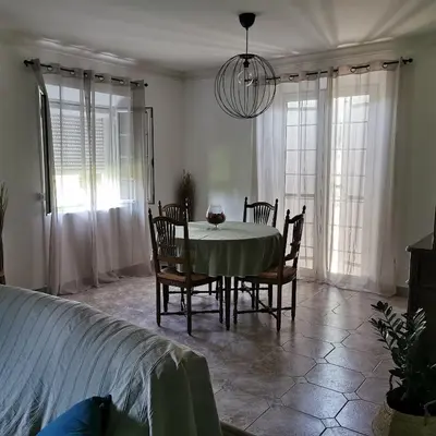 a dining room with a table and chairs and windows at Aux portes du Luberon in Cheval-Blanc