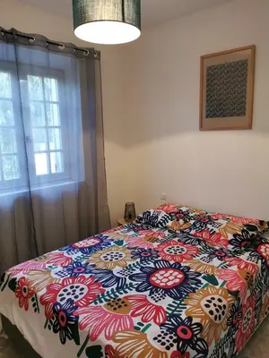 a bedroom with a bed with a colorful comforter at Aux portes du Luberon in Cheval-Blanc