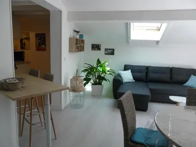 a living room with a couch and a table at Bleu de l'Isle in LʼIsle-sur-la-Sorgue