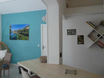 a dining room with a table and a blue wall at Bleu de l'Isle in LʼIsle-sur-la-Sorgue
