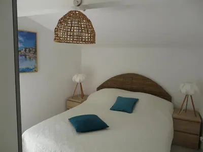 a bedroom with a bed with two blue pillows on it at Bleu de l'Isle in LʼIsle-sur-la-Sorgue