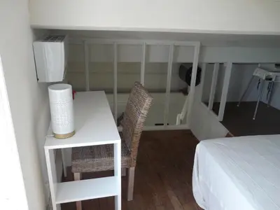 a bedroom with a bed and a desk and a table at Bleu de l'Isle in LʼIsle-sur-la-Sorgue
