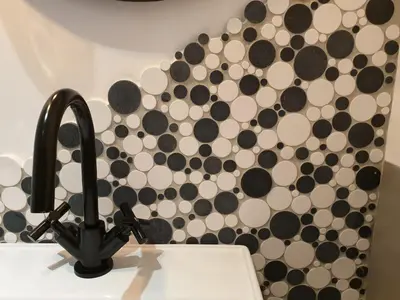 a bathroom sink with a black and white wall at Le Clos Marceau in Bédoin