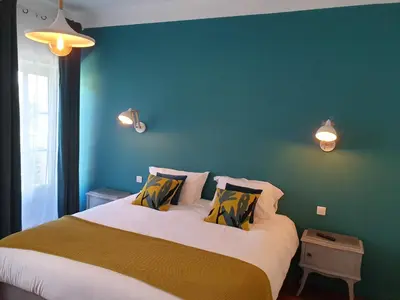 a bedroom with a large bed with a blue wall at Le Clos Marceau in Bédoin