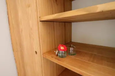 a wooden cabinet with two jars and a red flower at Sous le Château in Rustrel