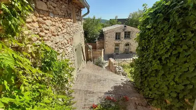 an alley with a stone building and a house at Sous le Château in Rustrel