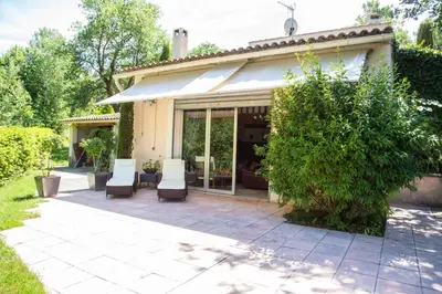 a patio with two white chairs and a house at Domaine en Provence Gîte la Ferrandiere in Carpentras